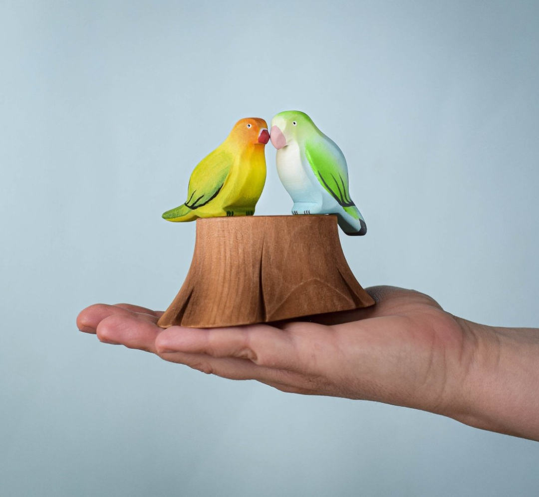 Pareja de agapornis con tronco de árbol