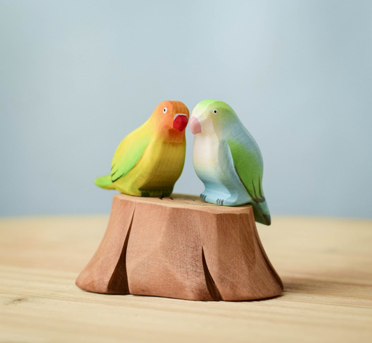 Pareja de agapornis con tronco de árbol